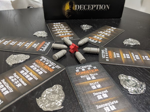 A red meeple surrounded by the components of Deception Murder in Hong Kong.